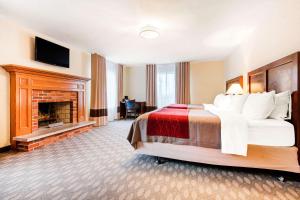 a hotel room with a bed and a fireplace at Comfort Inn Fallsview in Niagara Falls