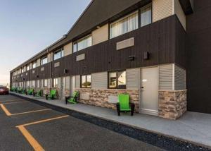 eine Reihe grüner Bänke vor einem Gebäude in der Unterkunft Quality Inn & Suites in Matane