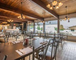 a dining room with tables and chairs and windows at Econo Lodge Forestville in Forestville