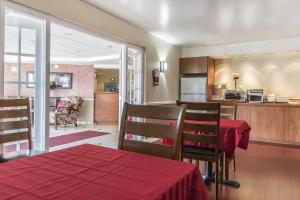 a dining room and kitchen with a red table and chairs at Econo Lodge in Orillia