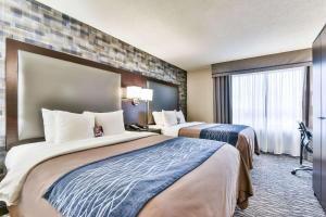 a hotel room with two beds and a window at Comfort Hotel Airport North in Toronto