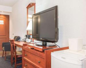 a television on top of a wooden dresser at Hotel Danube Bleu in Forestville +24 photos