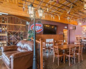 a restaurant with a couch and a table and chairs at Hotel Danube Bleu in Forestville