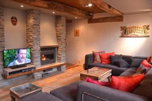 a living room with a couch and a fireplace at Les Bambous in La Roche-en-Ardenne