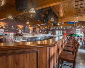 a bar with wooden counters and chairs in a restaurant at Hotel Danube Bleu in Forestville