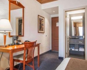 a room with a desk and a bed and a mirror at Hotel Danube Bleu in Forestville