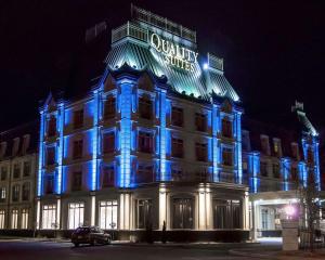 un edificio iluminado en luces azules por la noche en Quality Suites, en Drummondville