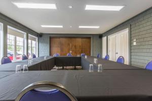 a conference room with a long table and blue chairs at Quality Inn in Rivière-du-Loup +59 photos