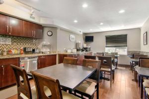 una grande cucina con tavolo e alcune sedie di Sleep Inn a Sault Ste. Marie