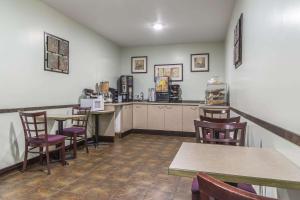 een restaurant met tafels en stoelen en een bar bij Econolodge Huntsville in Huntsville
