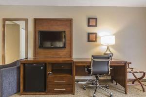 a room with a desk with a television and a chair at Comfort Inn in Saint-Georges