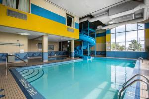 a swimming pool with a slide in a building at Comfort Inn & Suites Airport South in Calgary