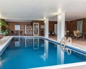 a swimming pool in a hotel with a restaurant at Quality Inn Mont-Laurier in Mont-Laurier