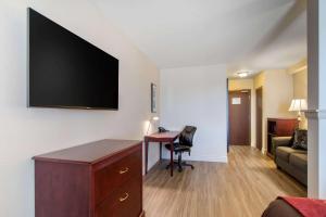 a hotel room with a desk and a flat screen tv at Comfort Inn & Suites Levis / Rive Sud Quebec city in Lévis