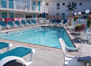a large swimming pool with chairs and a table at Aztec Motel in Wildwood Crest