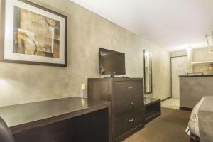 a hotel room with a bed and a flat screen tv at Quality Hotel & Conference Centre in Campbellton