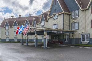 a large building with flags in front of it at Quality Inn in Rivière-du-Loup