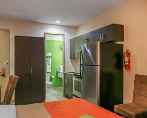 a kitchen with a stainless steel refrigerator and green walls at Econo Lodge Winnipeg South in Winnipeg
