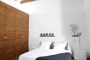 ソン・サルベーラにあるAmplia casa con piscina cerca playaの白いベッド1台(木製ヘッドボード付)が備わるベッドルーム1室が備わります。