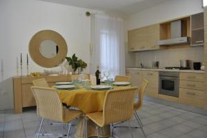 - une cuisine avec une table, des chaises et un miroir dans l'établissement Residence Tamerici, à Caorle