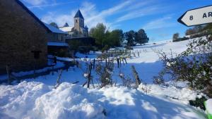 um quintal coberto de neve com uma placa de rua em Auberge à la Vieille Cure em Arandas