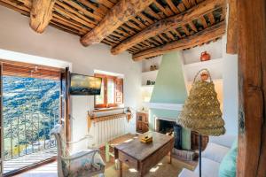 a living room with a fireplace and a christmas tree at Casa La Parra in Capileira