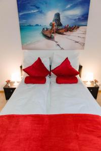 a bedroom with a large bed with red pillows at Luxury flat between Cologne and Bonn and Phantasialand Bruhl in Wesseling