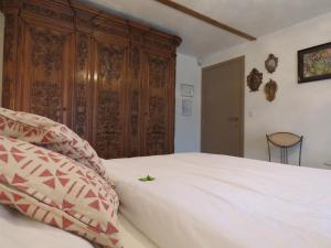 a bedroom with a large white bed and a wooden cabinet at Guesthouse La maison de Fille in Diest