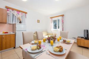 a table with plates of food on it in a kitchen at Villas Rab Palit in Rab