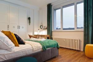 1 dormitorio con cama y ventana grande en Szczecin Old Town Apartments - 2 Bedrooms Deluxe, en Szczecin