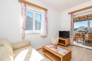a living room with a couch and a tv at Villas Rab Palit in Rab
