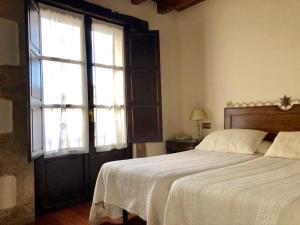 
a bedroom with a bed and a window at Hotel Rey Chindasvinto in Covarrubias
