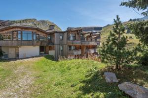 a large wooden house on a hill with a tree at Residence Le Sepia - maeva Home in Avoriaz