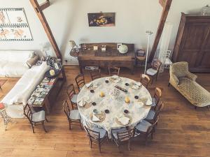 uma sala de jantar com uma mesa e cadeiras e um sofá em Gorgeous manor in the Auvergne with private pool em Meaulne