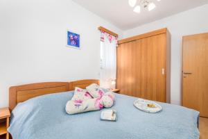 a bed with some pillows on top of it at Villas Rab Palit in Rab