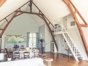 ein Wohnzimmer mit einem Tisch und einer Treppe in der Unterkunft Gorgeous manor in the Auvergne with private pool in Meaulne