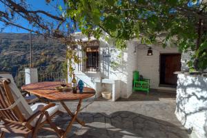 un patio con mesa y sillas y un edificio en Casa La Parra, en Capileira