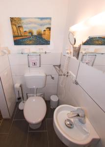 a bathroom with a toilet and a sink at Hotel und Restaurant Löwenbräu Köln in Cologne