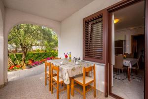 ein Esszimmer mit einem Tisch und Stühlen auf einer Terrasse in der Unterkunft Garden paradise App in Sveti Vid-Miholjice