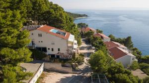 an aerial view of a house on a hill next to the water at Apartments Vranjes Deluxe in Brela