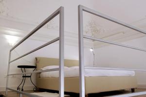 a white bedroom with a bed and a chair at Ognina Residence in Catania