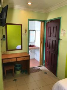 a bedroom with a mirror and a dresser and a door at Hotel dan Restoran Seri Kangsar in Kuala Kangsar +11 photos