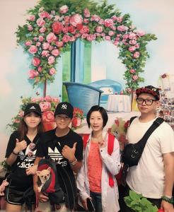 a group of people standing in front of an arch with roses at Garden Rose Homestay in Taitung City