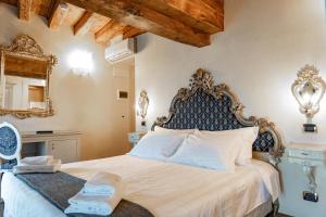 Un dormitorio con una gran cama blanca con cabecero azul. en Hotel Vecellio Venice on the Lagoon, en Venecia