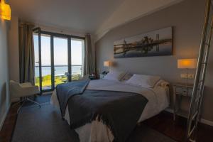 a bedroom with a bed with a view of the ocean at Hotel Arbe in Mutriku