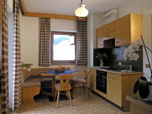 una cucina con tavolo e una sala da pranzo di Apartments Ruac a La Valle