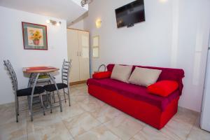 a living room with a red couch and a table at Apartments Lara in Podgora