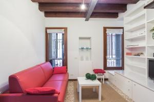 ein Wohnzimmer mit einem roten Sofa und einem TV in der Unterkunft Cà della Regina in Venedig