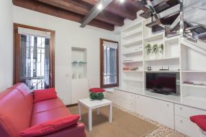een woonkamer met een rode bank en een tv bij Cà della Regina in Venetië