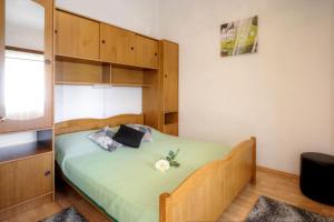 1 dormitorio con 1 cama con armarios de madera en Apartments Grozdana, en Baška